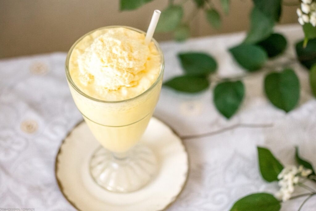 top-down view of frothy carnivore smoothie with straw and creamy foam